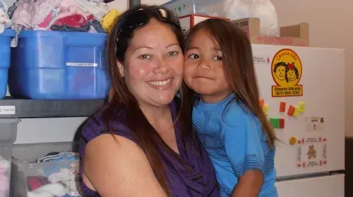 a woman is holding a little girl in her arms .