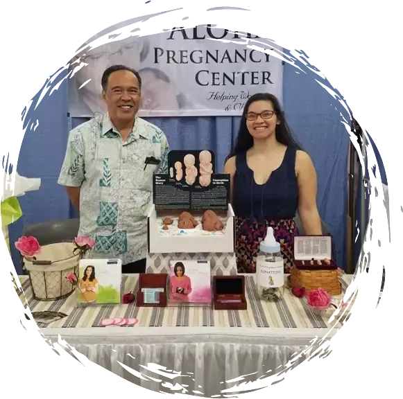 a man and a woman standing in front of a sign that says pregnancy center