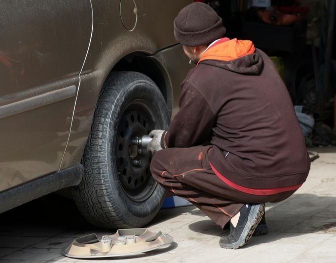 a mechanic fixing the tires of a car
