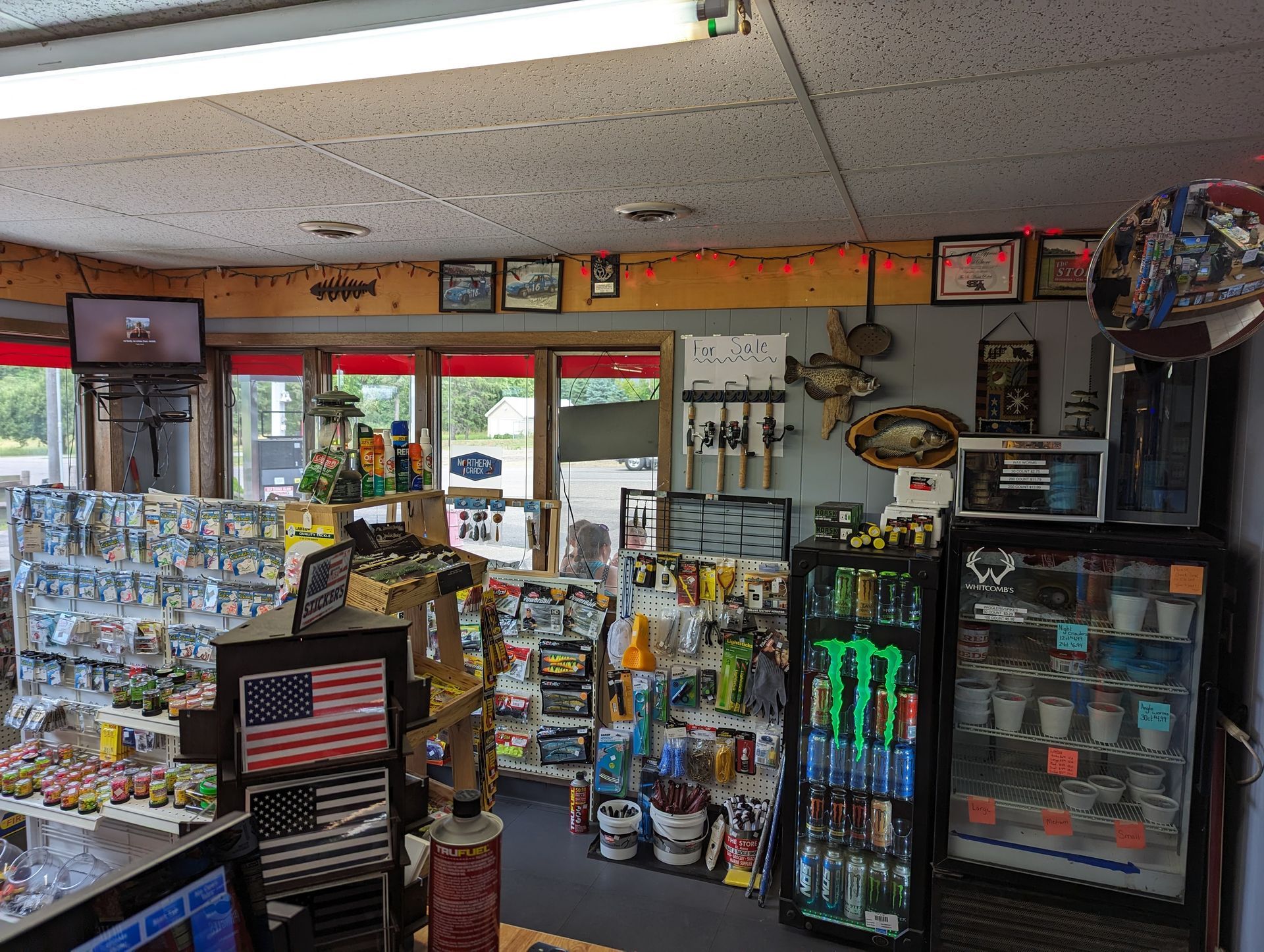 A store filled with lots of items including a monster energy drink cooler.