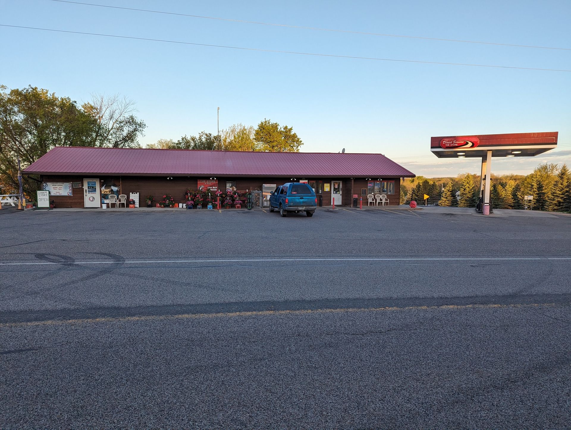 A blue truck is parked in front of a gas station.