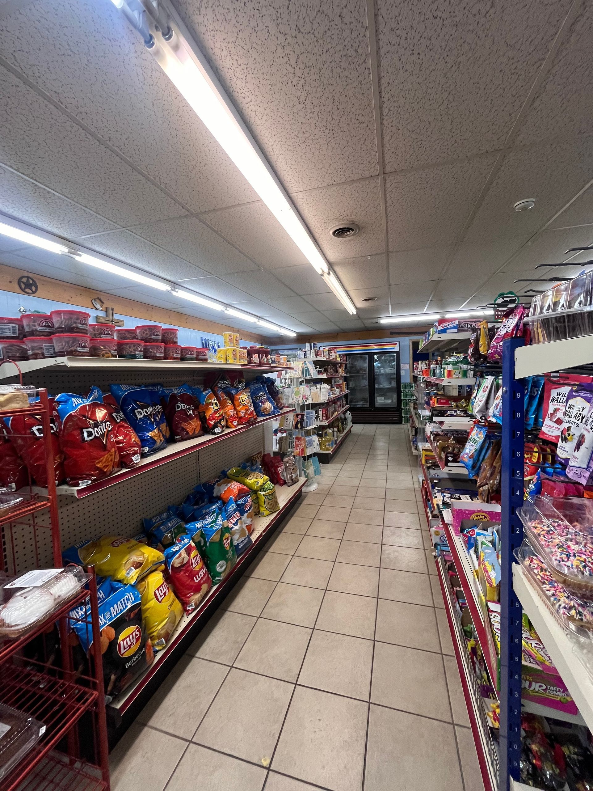 A grocery store aisle filled with lots of snacks and candy