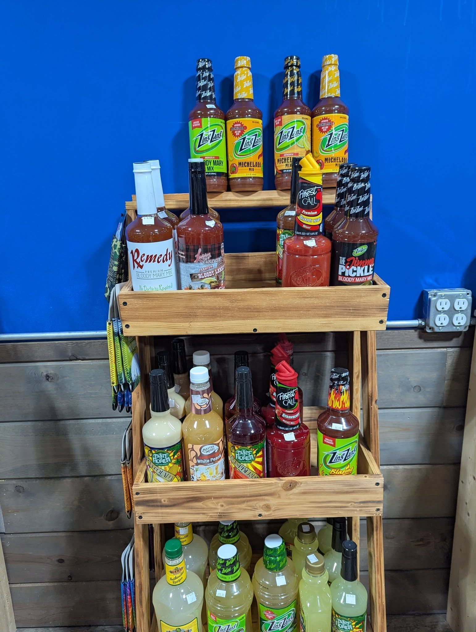 A wooden shelf filled with bottles of hot sauce.
