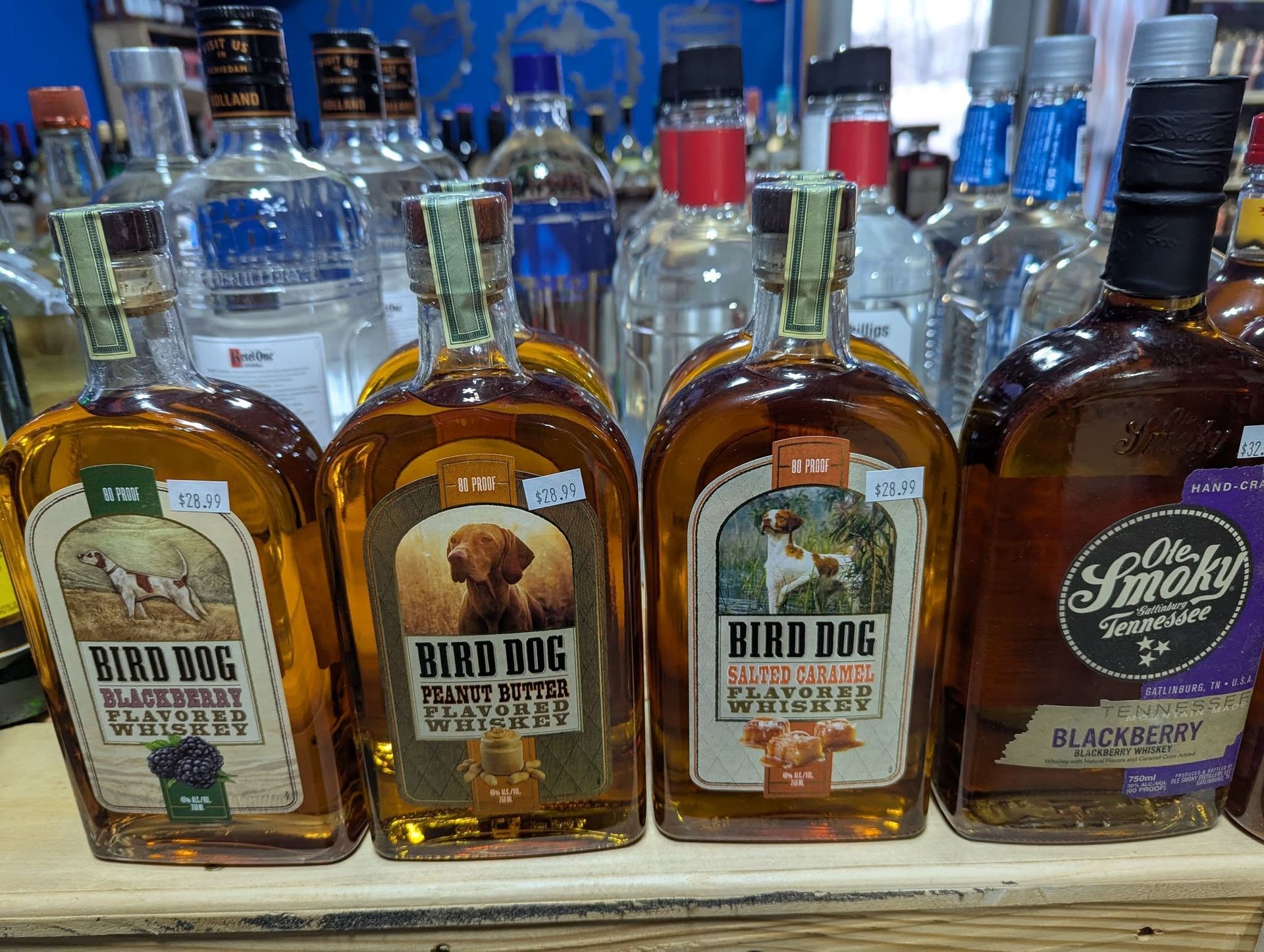 Four bottles of bird dog whiskey are lined up on a table.