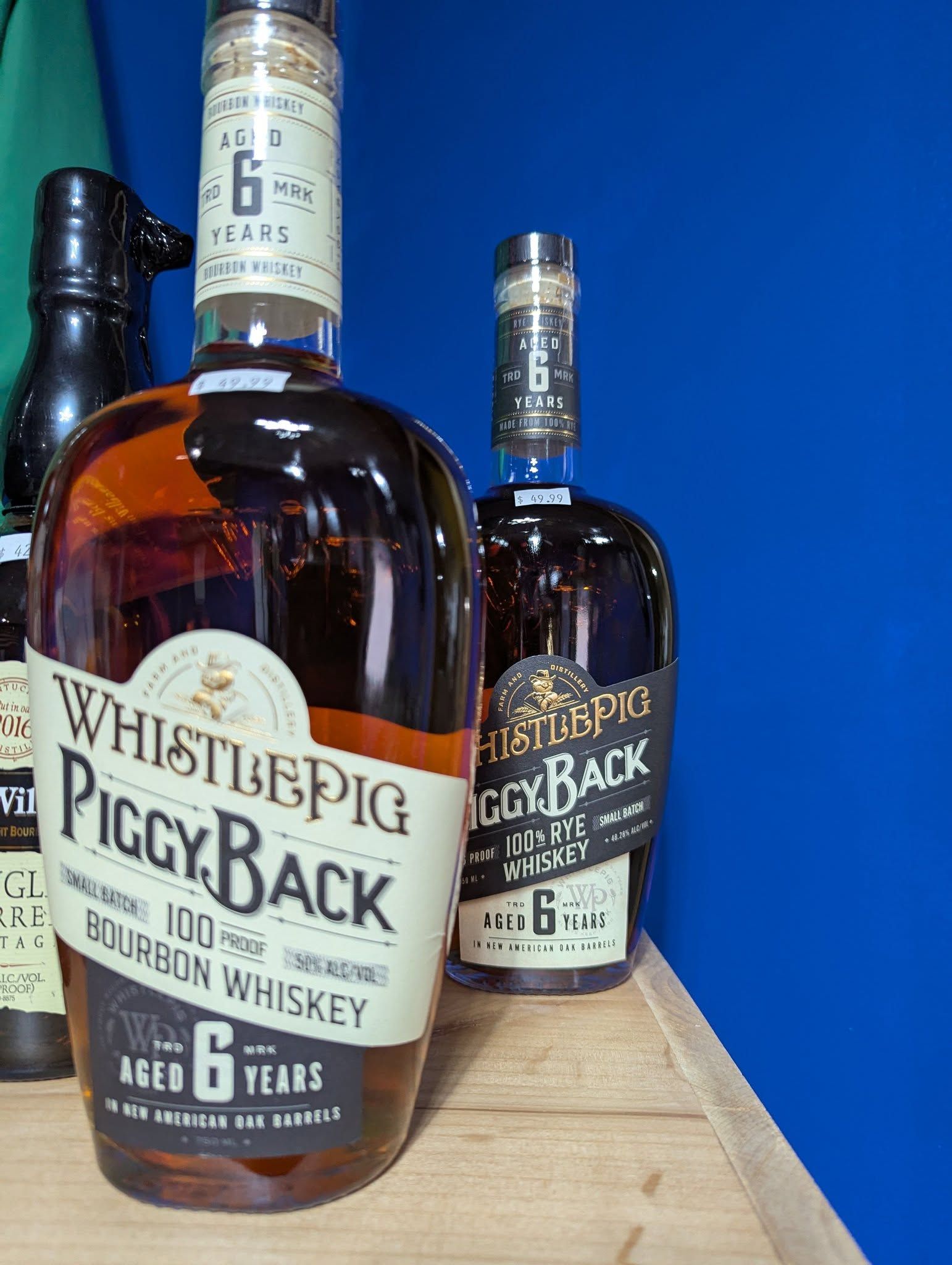 Two bottles of whiskey are sitting on a wooden table.