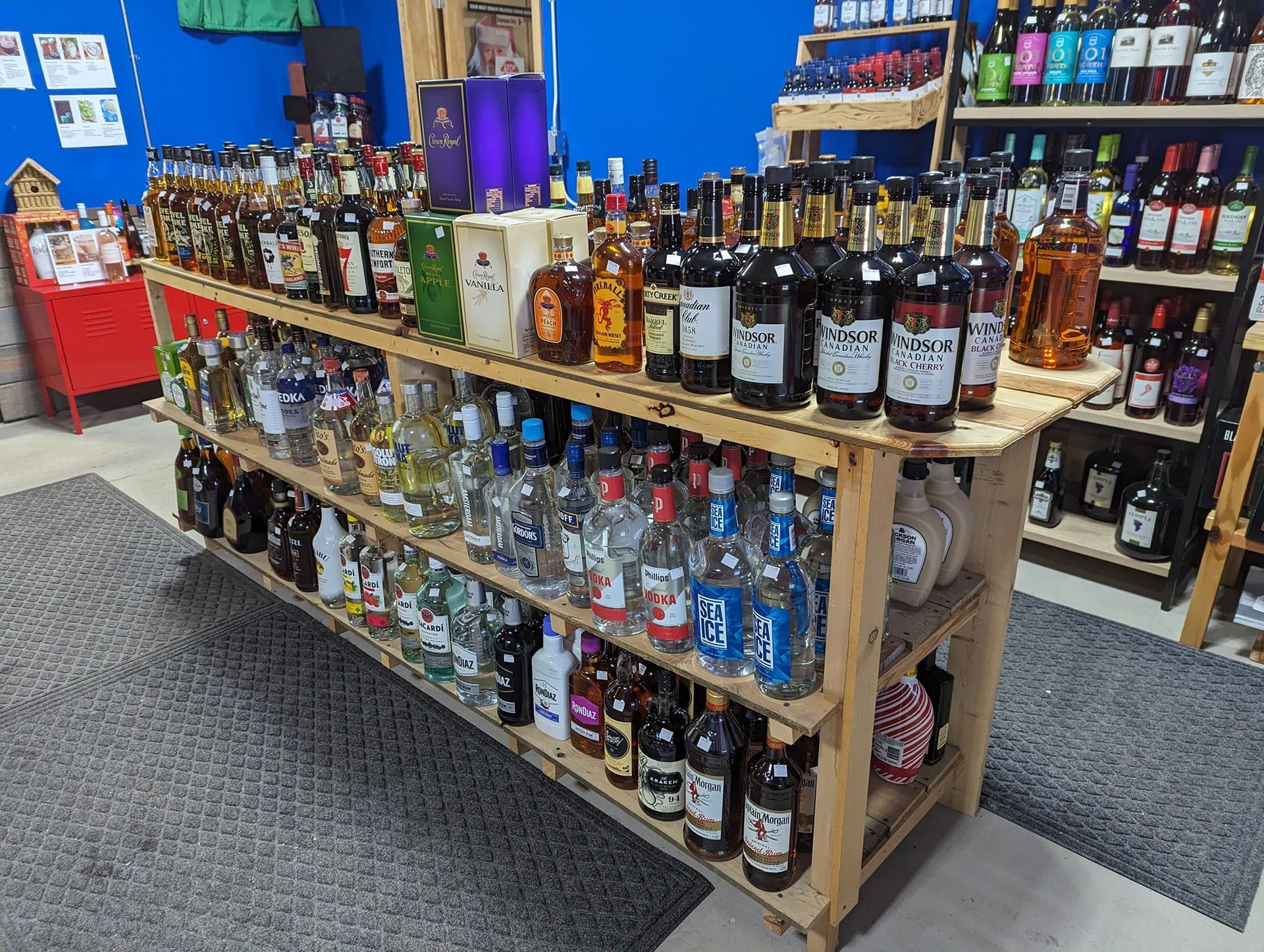 A wooden shelf filled with lots of bottles of liquor