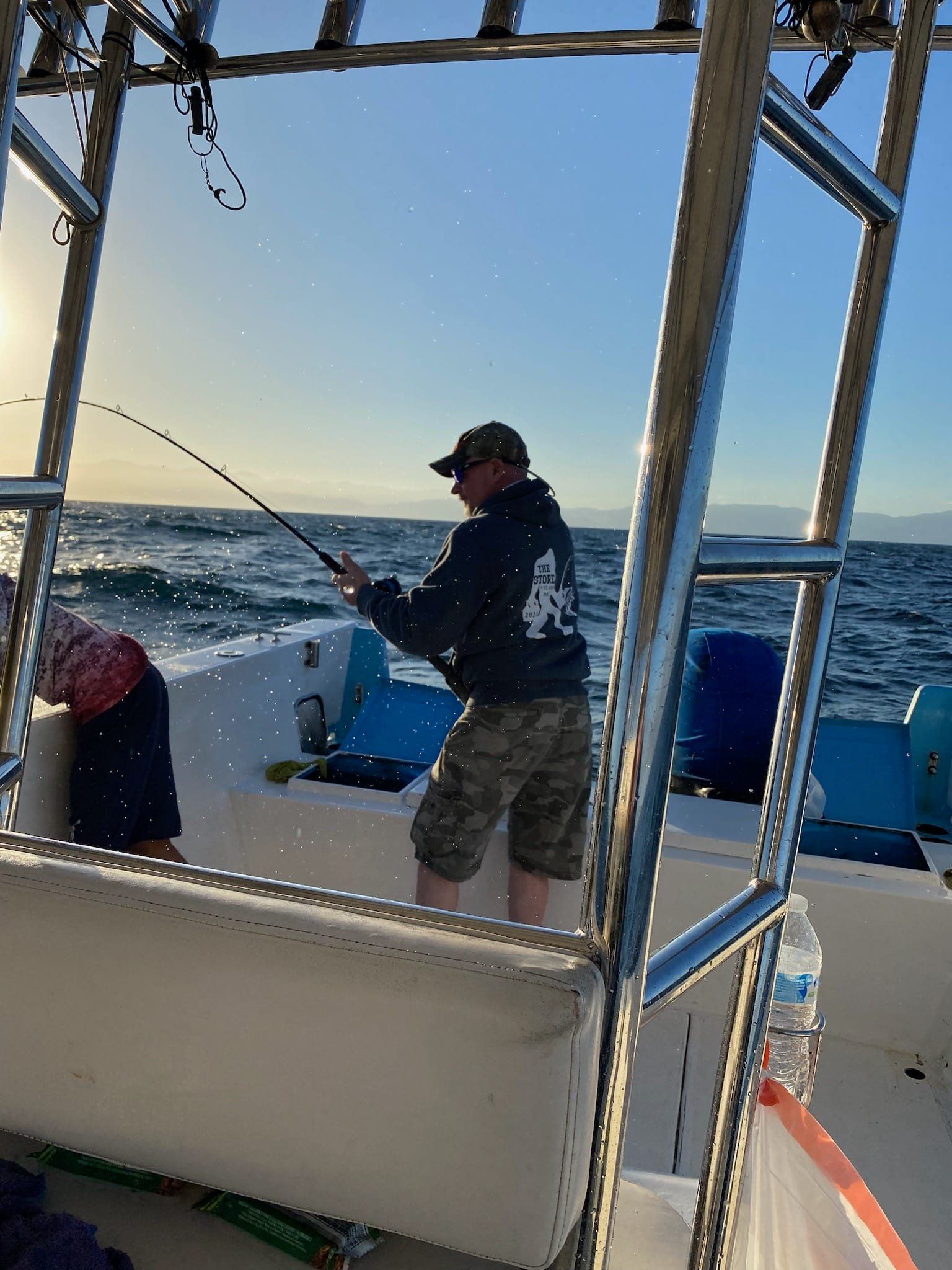 A man is fishing on a boat in the ocean