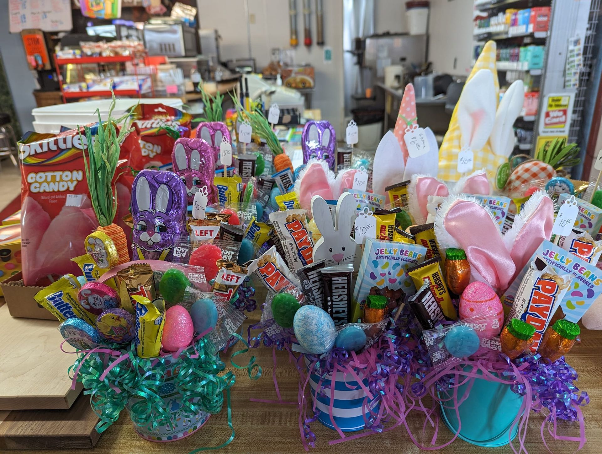 A table topped with easter baskets filled with candy and bunny ears.