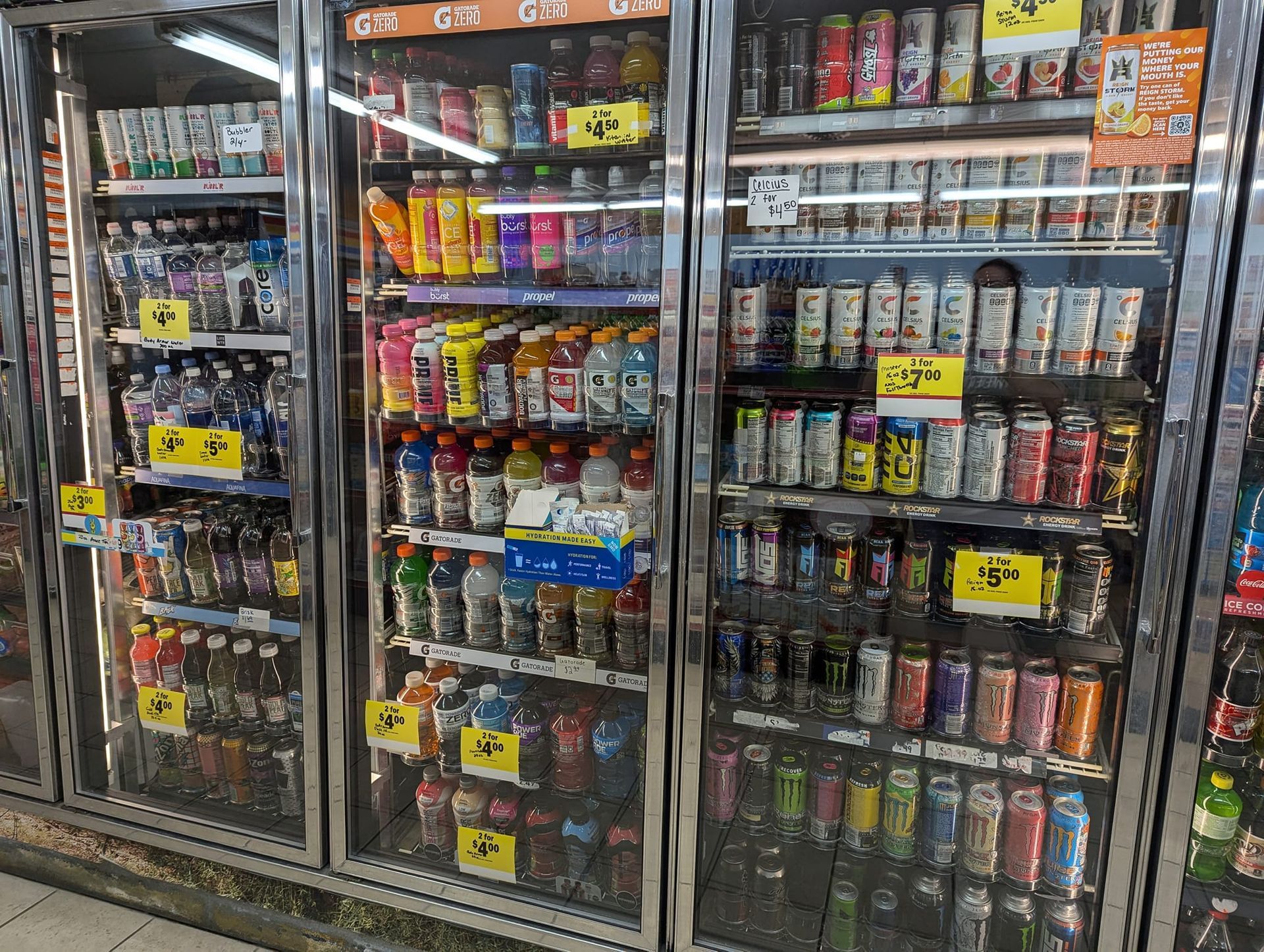 A refrigerator filled with lots of cans and bottles of soda.