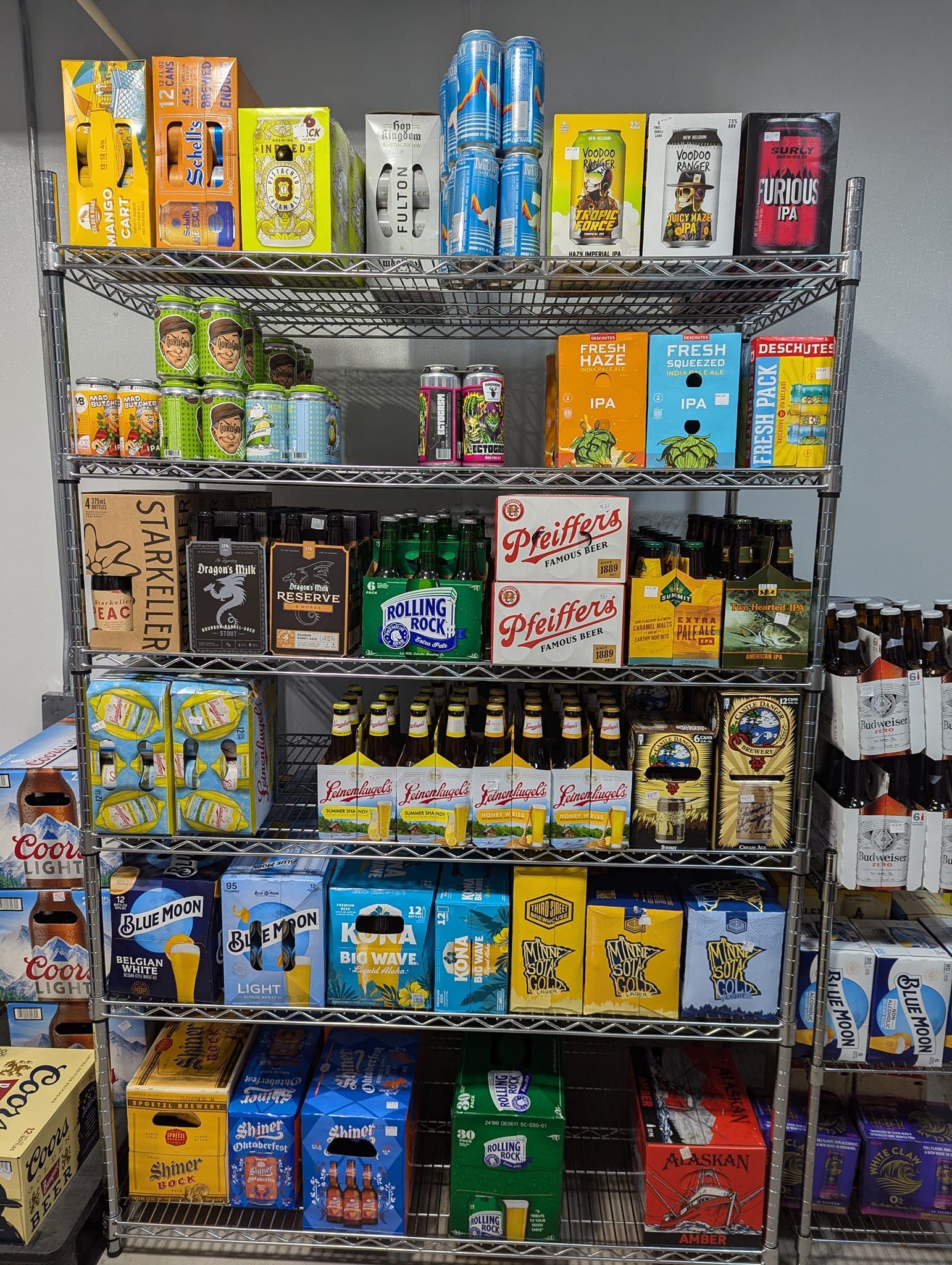 A shelf filled with lots of different types of beer.