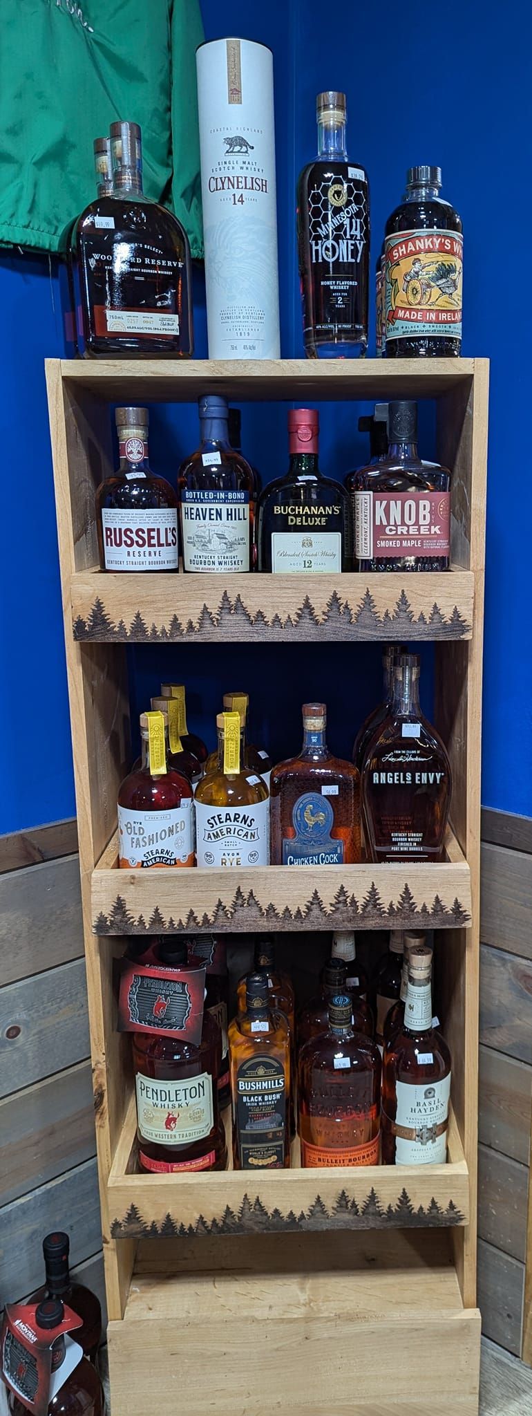 A wooden shelf filled with lots of bottles of liquor.