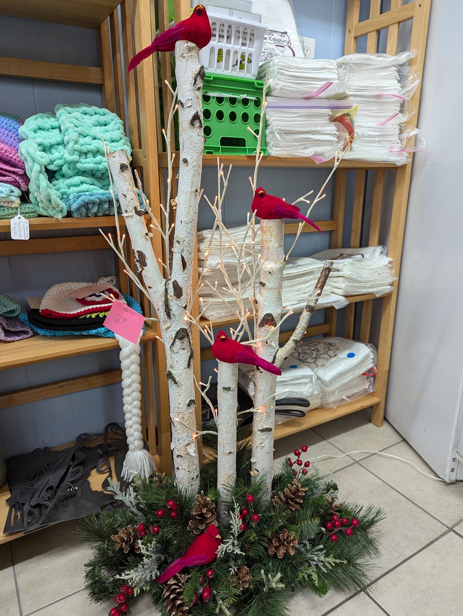 A christmas tree with red cardinals on it in a store.