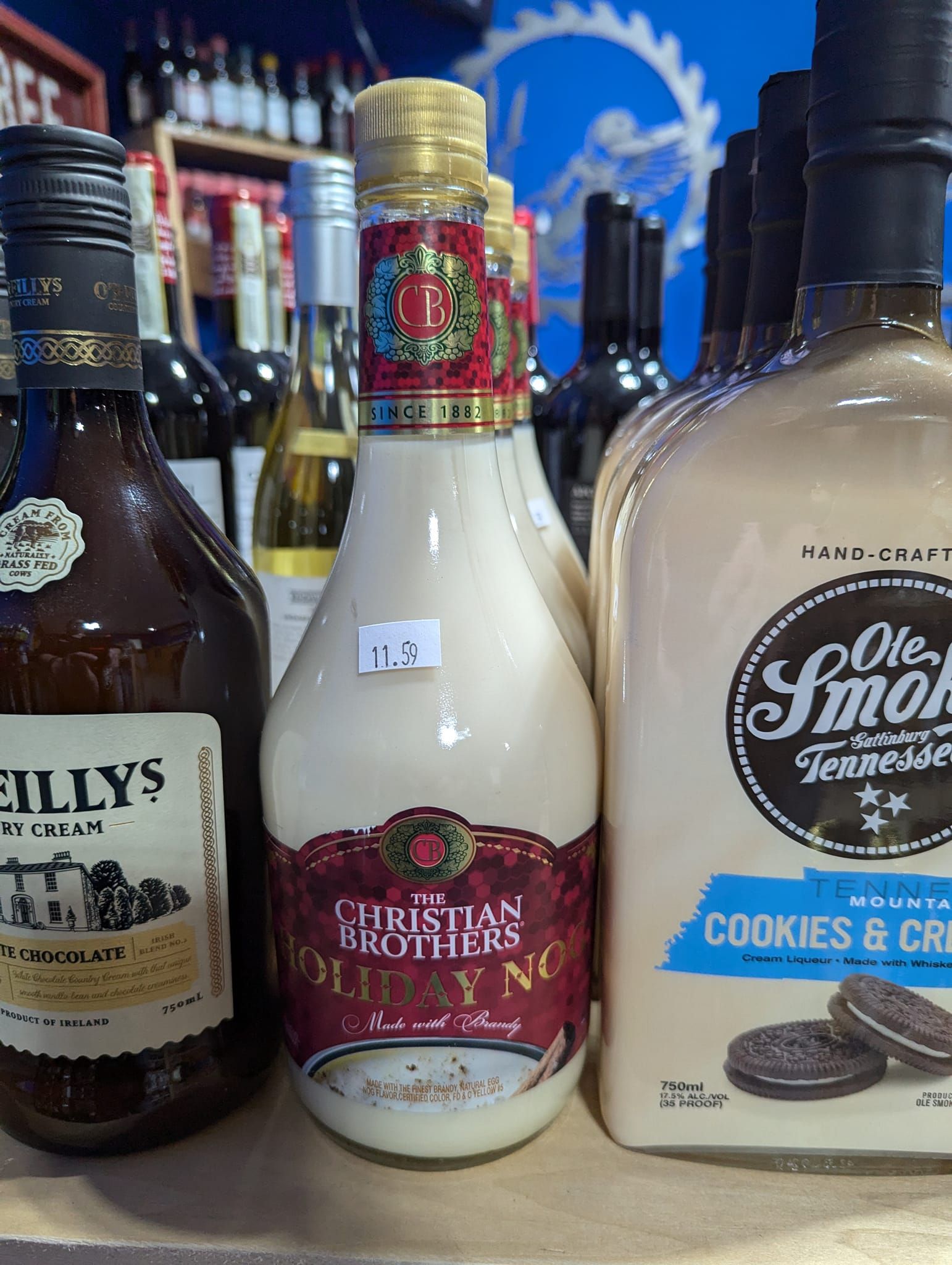 Three bottles of liquor are sitting on a shelf in a store.