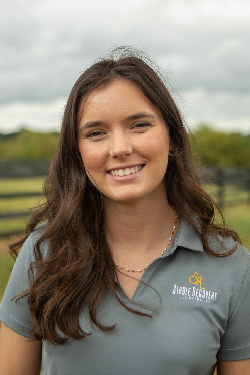 A man with a beard is wearing a baseball cap and a black shirt.