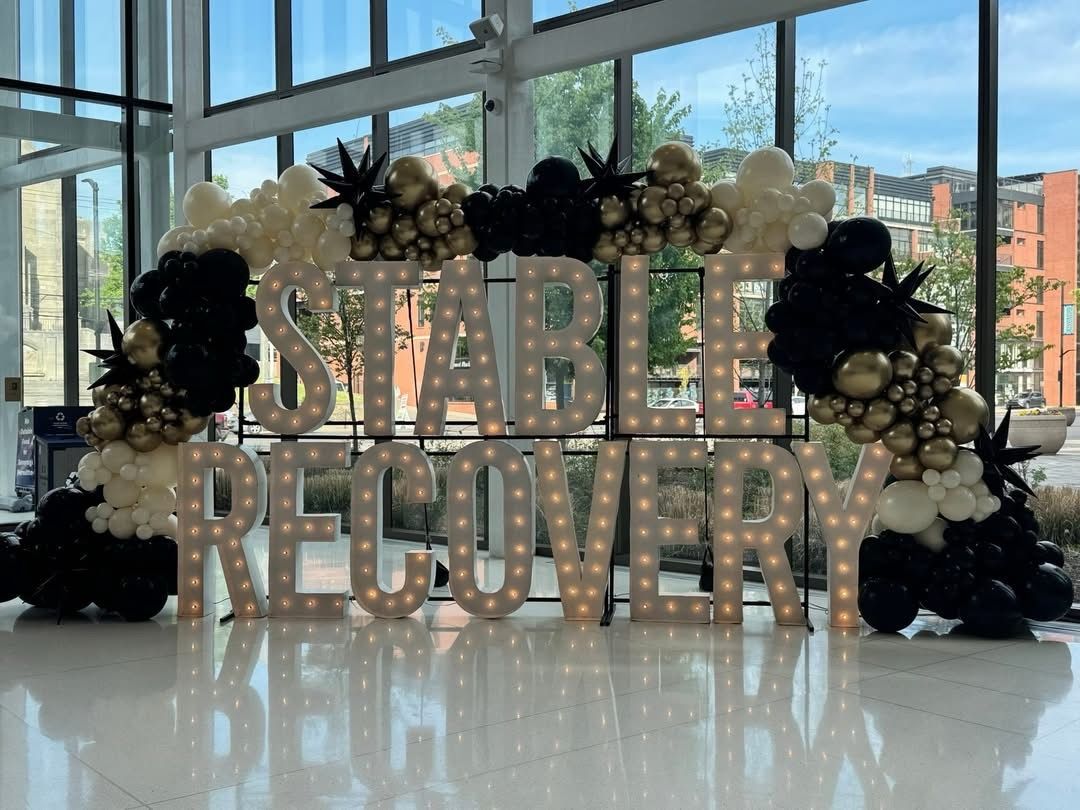 A man hugs a woman while people sit at a table.