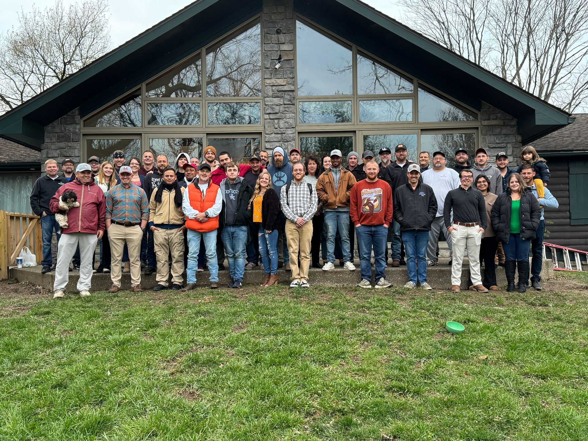 A group of people are posing for a picture in front of a house.