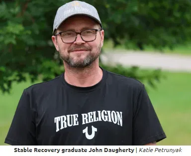 A man wearing glasses and a true religion shirt