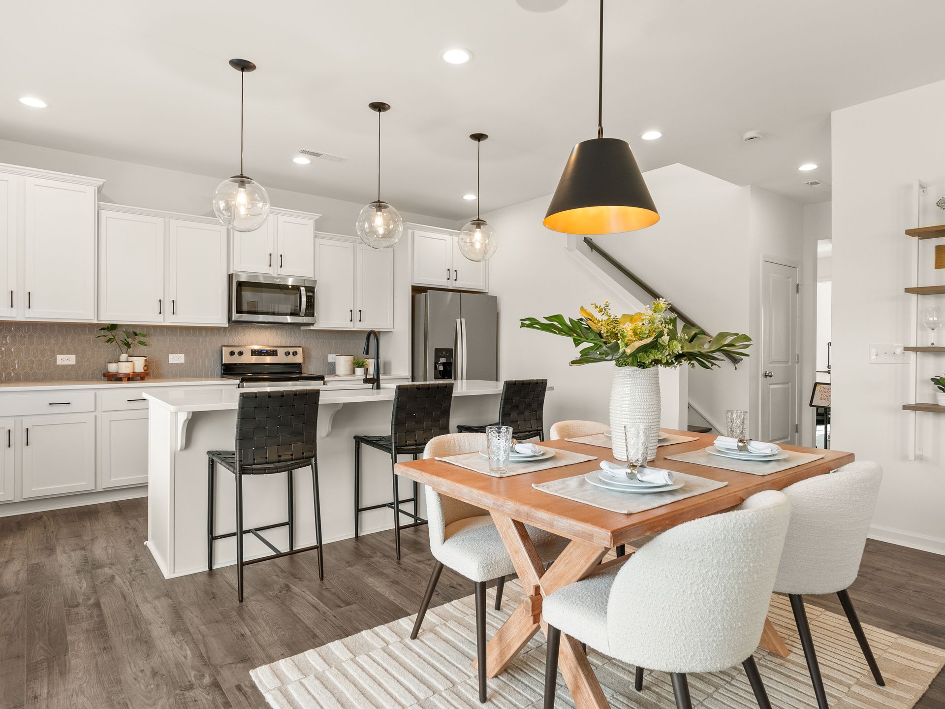 A kitchen and dining room in a house with a table and chairs.
