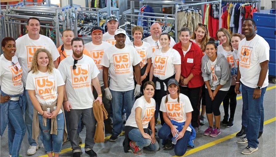 A group of people wearing us day shirts are posing for a picture