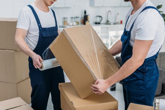 Movers Wrapping Cardboard Box — Premier Removals & Storage in Coffs Harbour, NSW