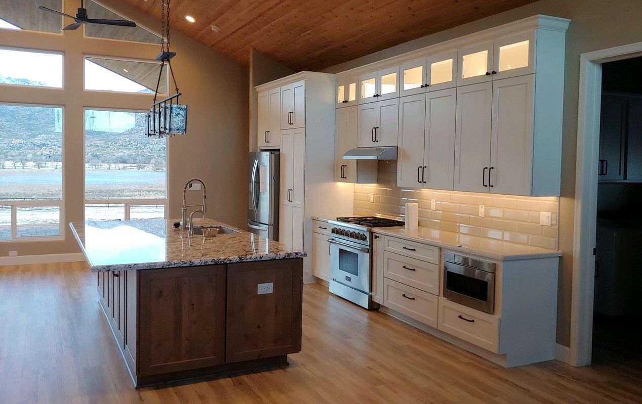 Kitchen with white cabinets, wood island, and stainless steel appliances.