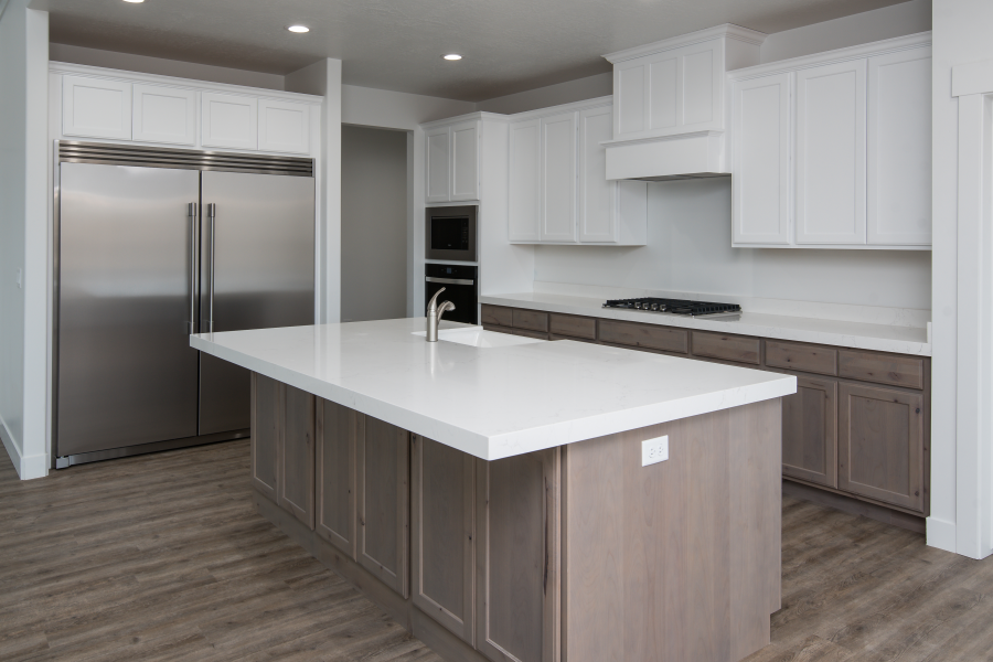 Modern kitchen with white upper cabinets, gray lower cabinets, and a large island.