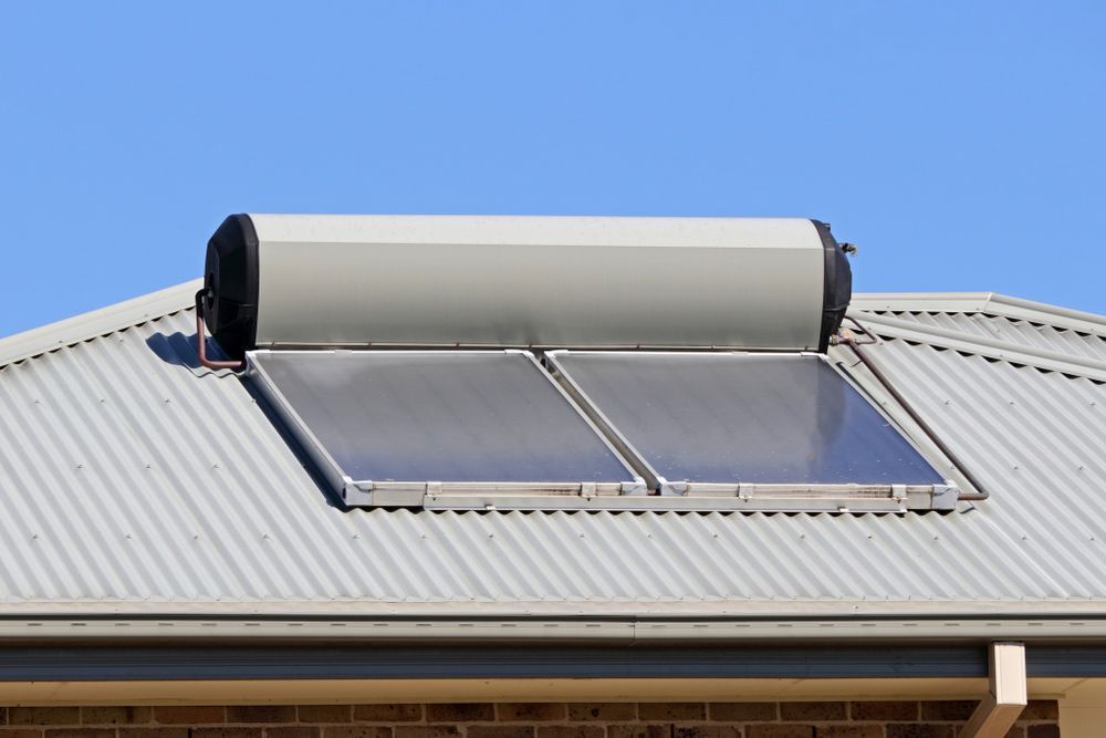 Solar water heater and two solar panels on a corrugated metal roof