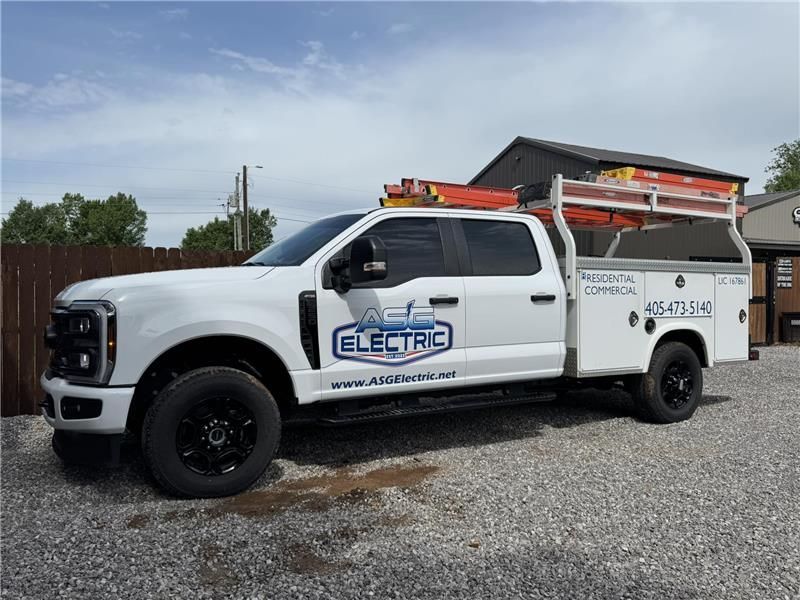 White ACG Electric truck with black wheels parked in front of a building.