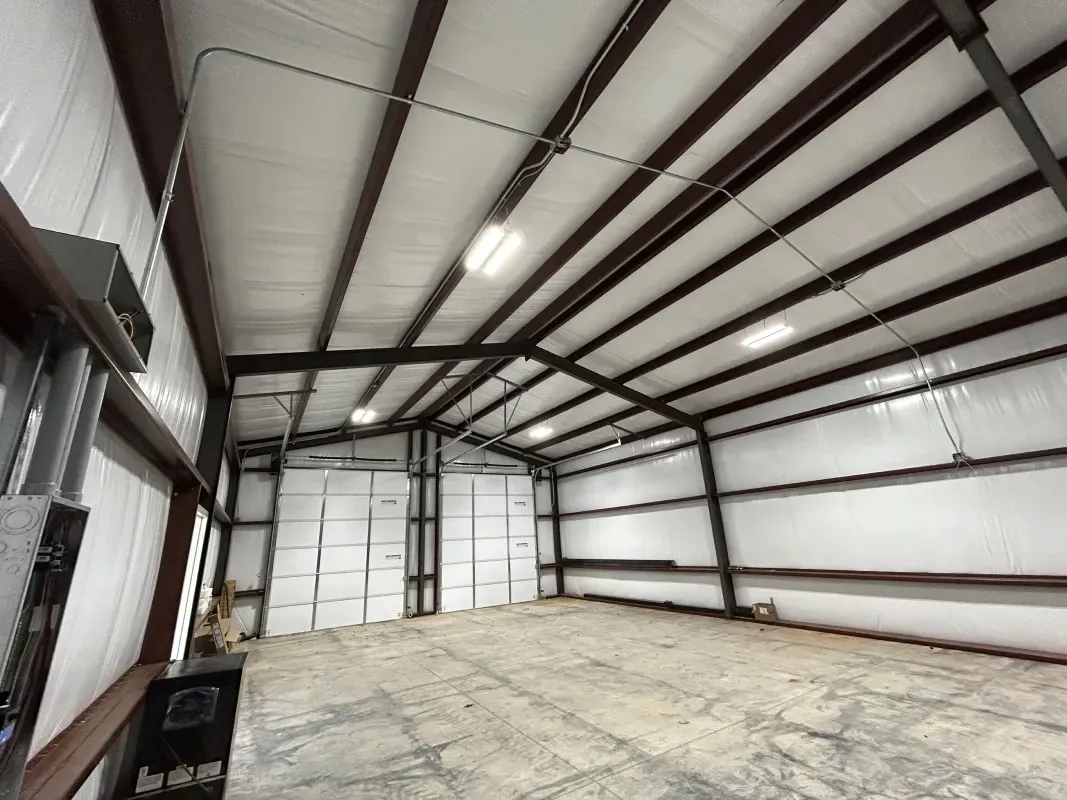 Empty industrial warehouse with metal frame and lighting.