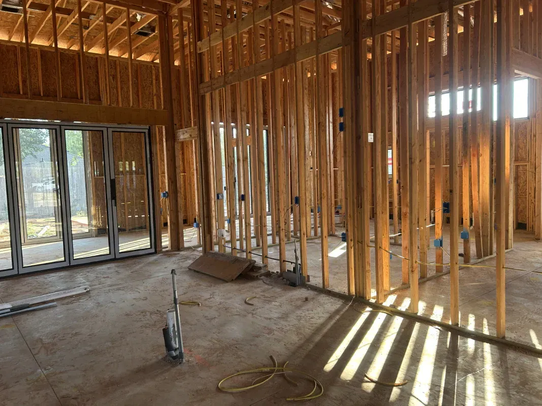 Interior framing of a house under construction, showing studs and window frame.