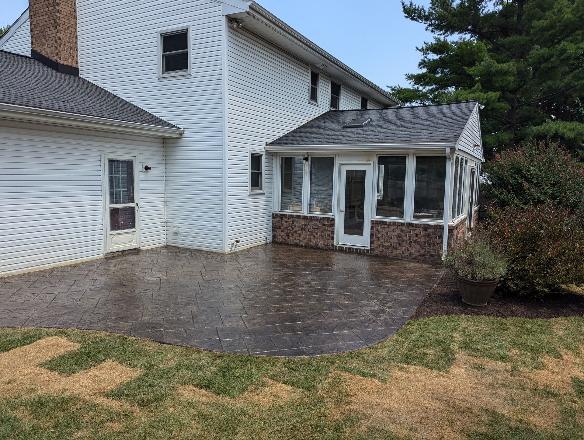 A home with a patio and screened-in porch. The patio is dark grey.