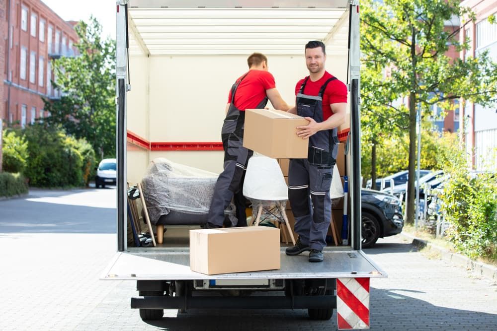 Two Men Loading Boxes Into a Moving Truck — Town & Country Removals In Port Macquarie, NSW