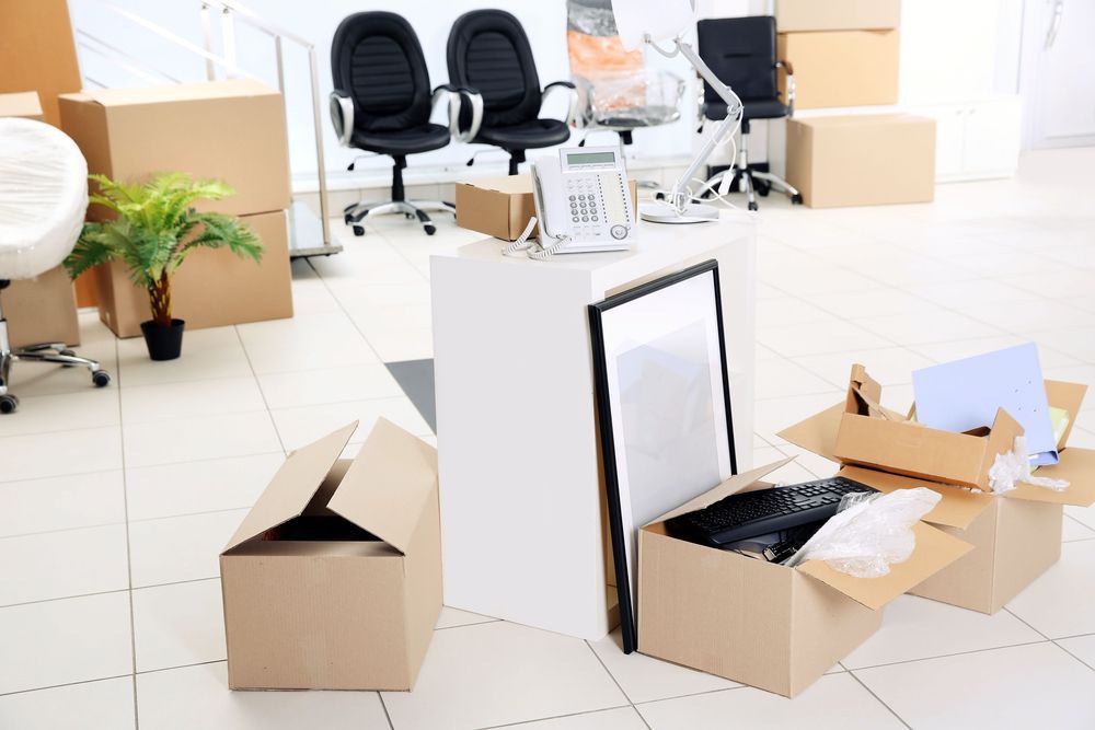 A Moving Office With Boxes and Chairs on the Floor — Town & Country Removals In Kempsey, NSW