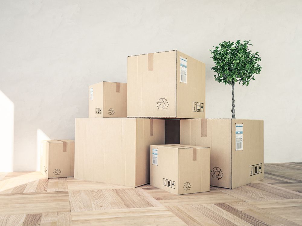 A Bunch of Cardboard Boxes Are Stacked on Top of Each Other on A Wooden Floor — Town & Country Removals In Port Macquarie, NSW