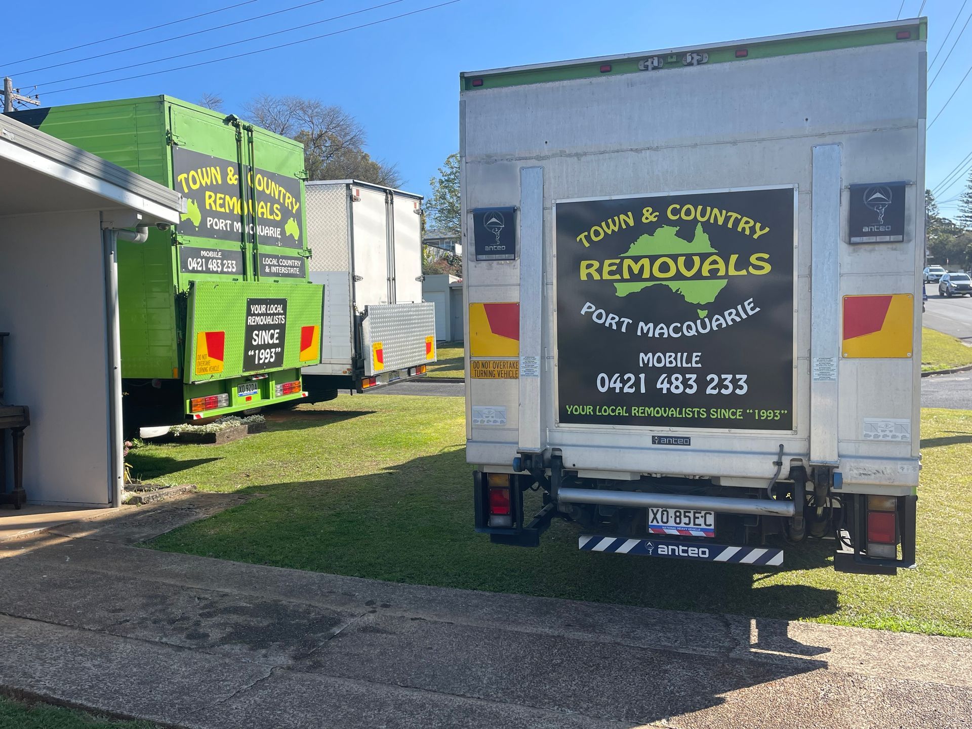 A Green Moving Truck Parked on Grass — Town & Country Removals In Port Macquarie, NSW