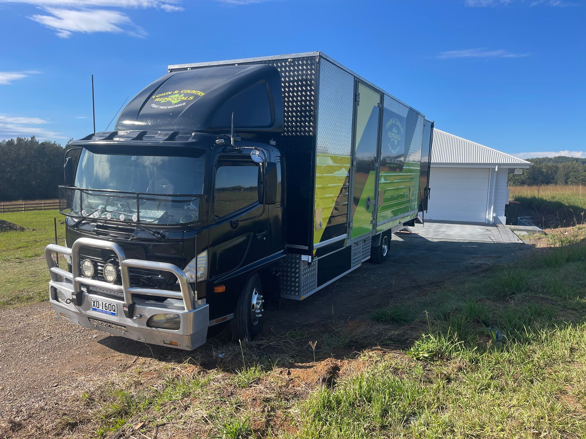 A Back Moving Truck Parked on Grass — Town & Country Removals In Port Macquarie, NSW