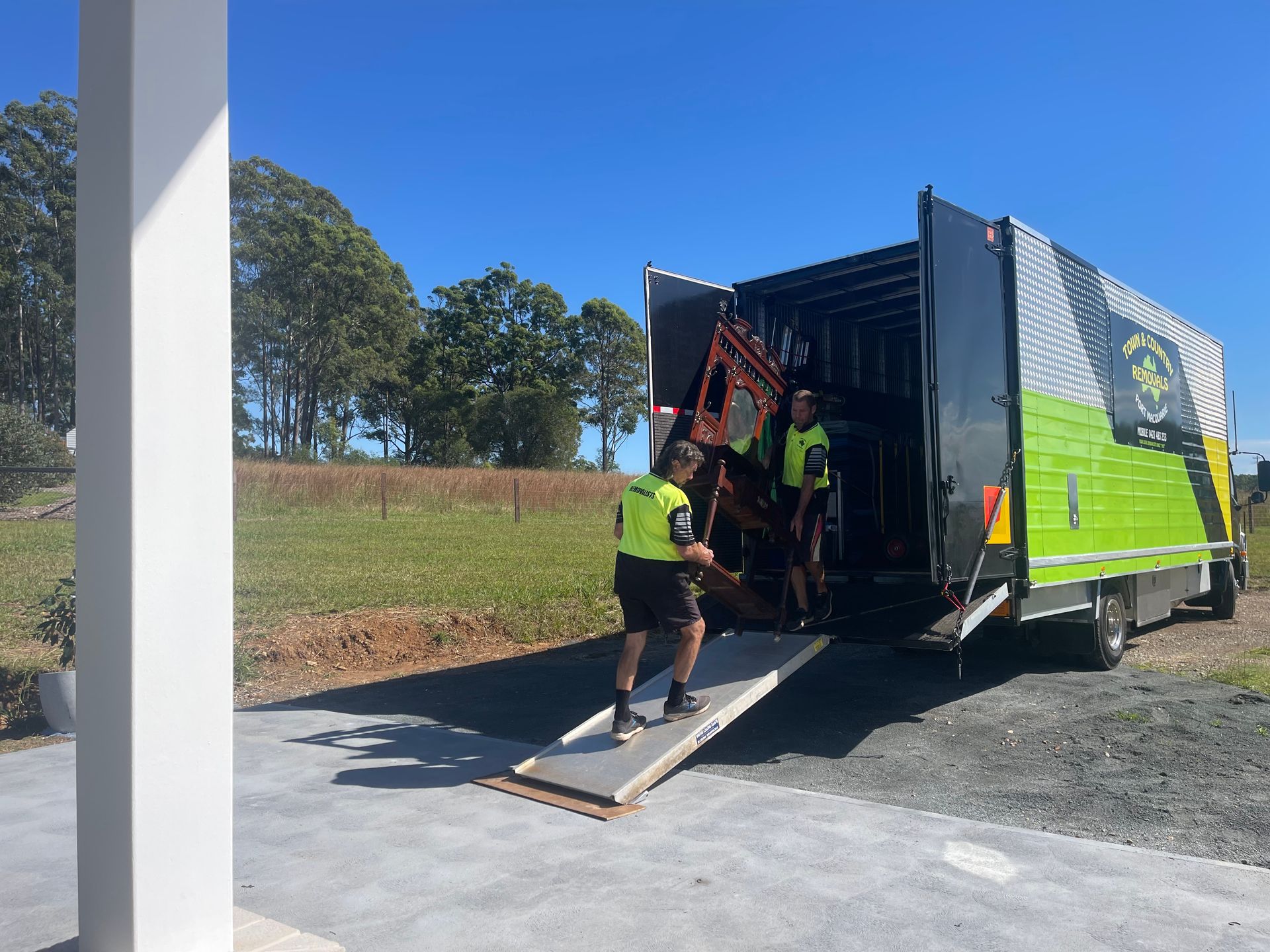 Two Men Unloading  Into a Van — Town & Country Removals In Port Macquarie, NSW