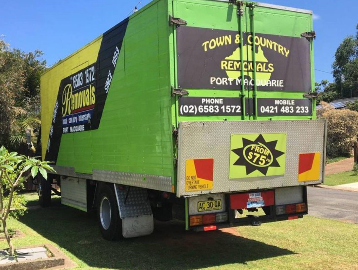 A Green and Yellow Truck that Says Town & Country Removals — Town & Country Removals In Laurieton, NSW