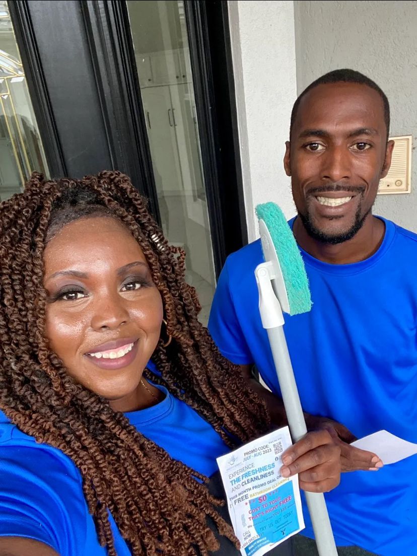 A man and a woman are standing next to each other holding a mop.