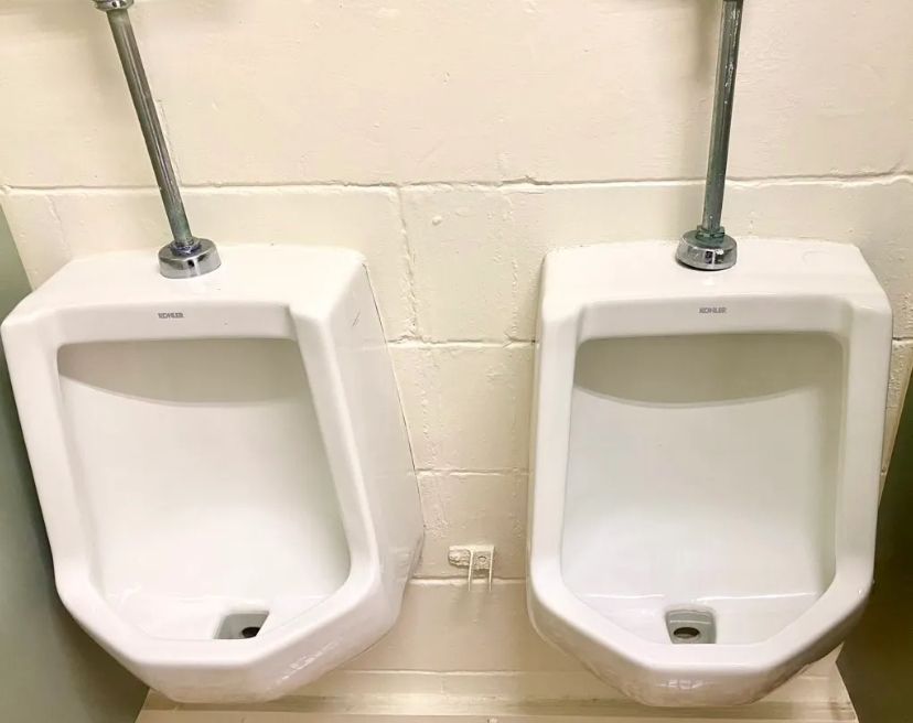 Two urinals are sitting next to each other in a bathroom. BEFORE/AFTER