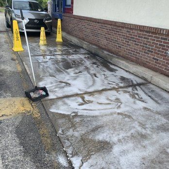 A car is parked in a parking lot next to a brick building. BEFORE/AFTER