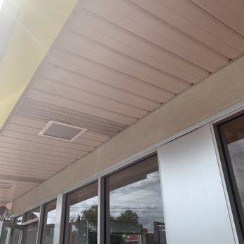 The ceiling of a building with a speaker on it. BEFORE/AFTER