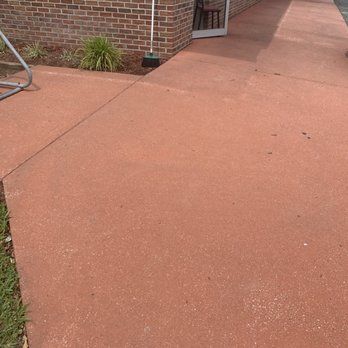 A red concrete walkway leading to a brick building.  BEFORE/AFTER