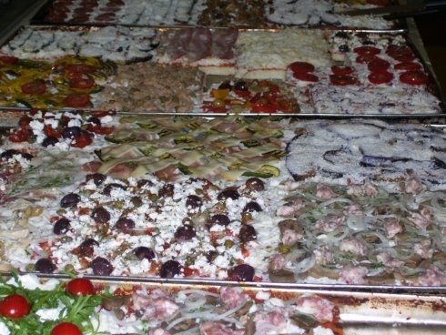 delle pizze in teglia farcite pronte per essere infornate