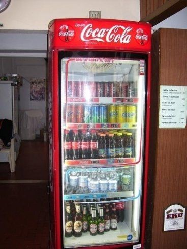 un frigorifero con dentro delle bibite e la scritta Coca Cola