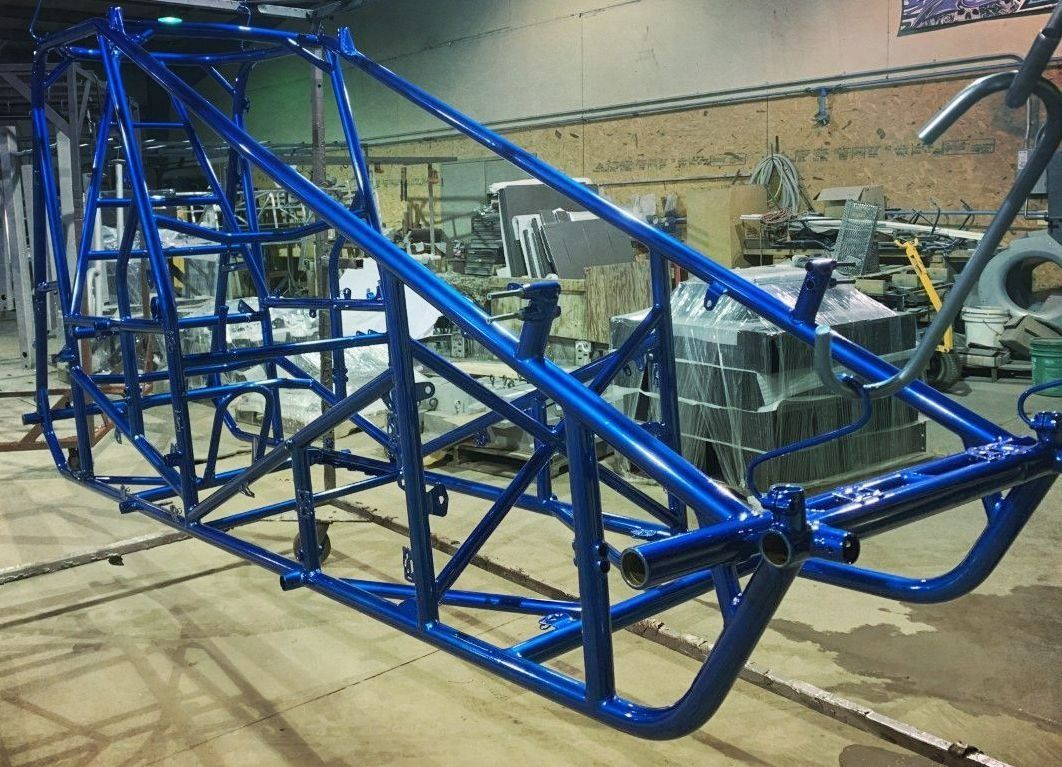 Blue race car chassis in a workshop.