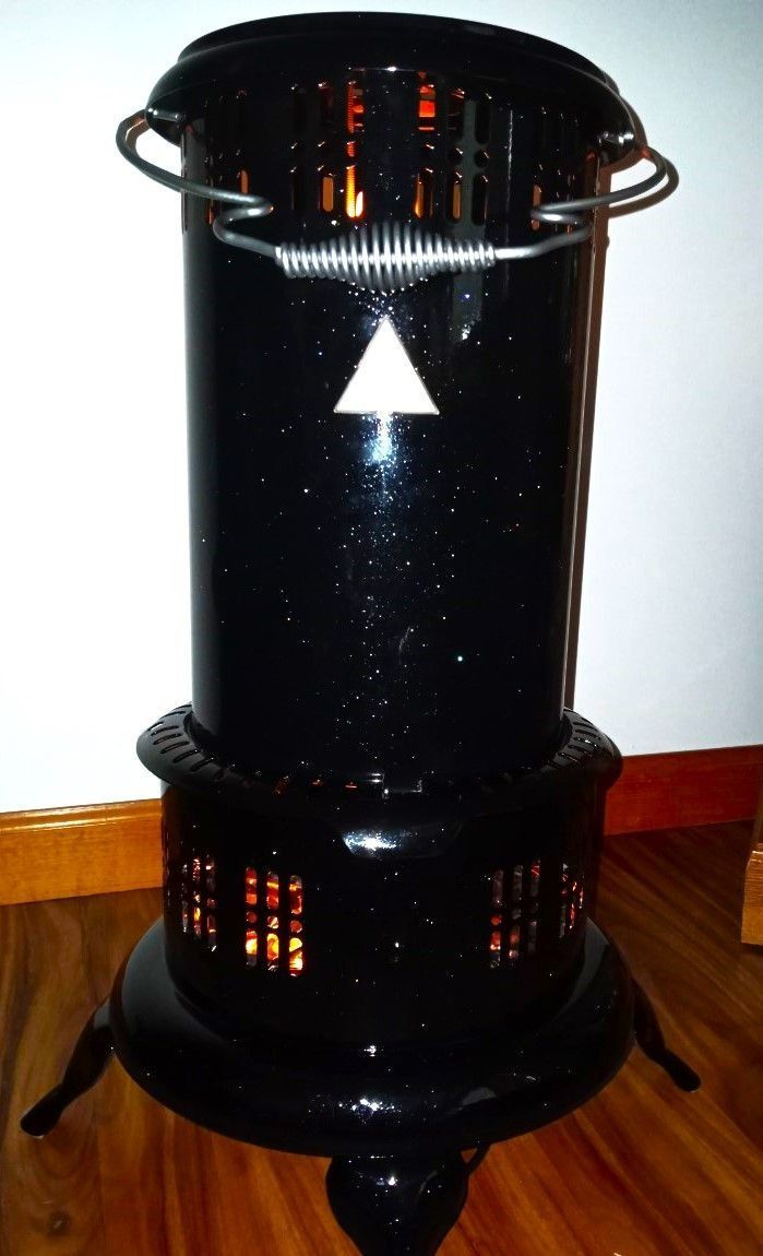 Black kerosene heater with a decorative triangle, on a wooden floor.