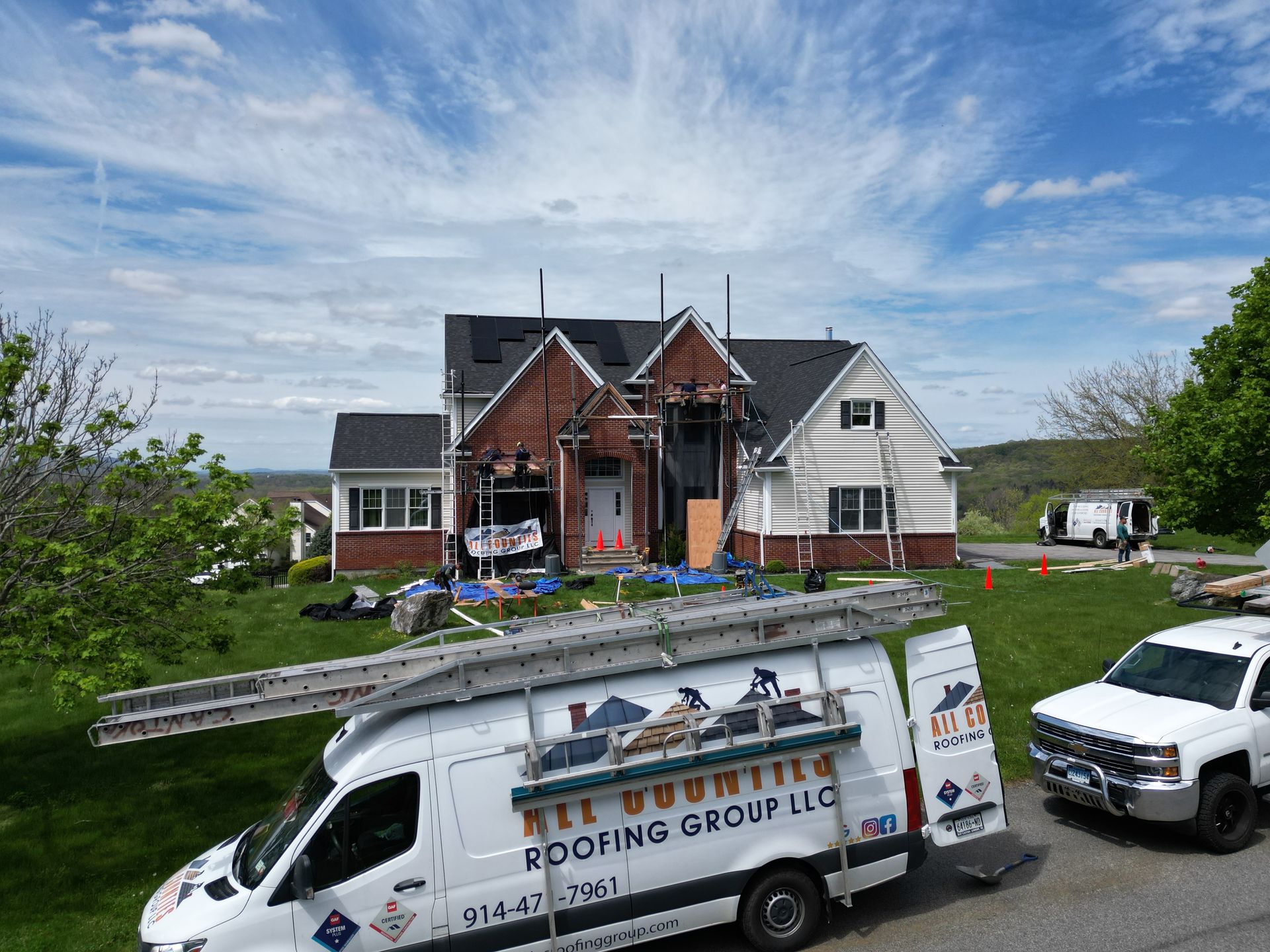 All Counties Roofing Group vehicles outside of roof and siding project
