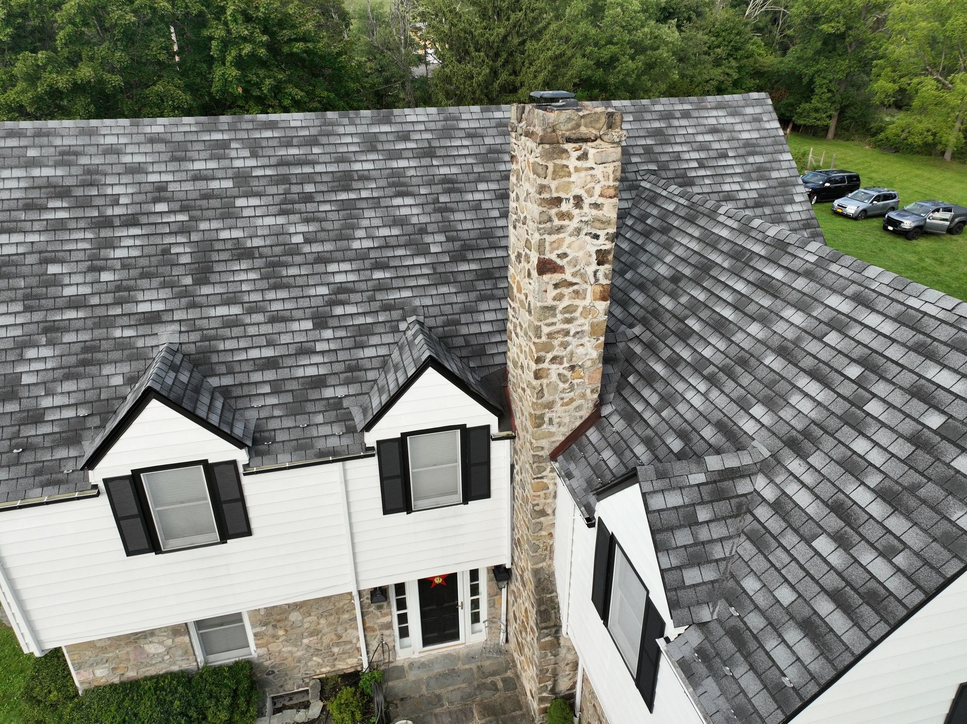 An aerial view of a large house with a custom shingle roof installation