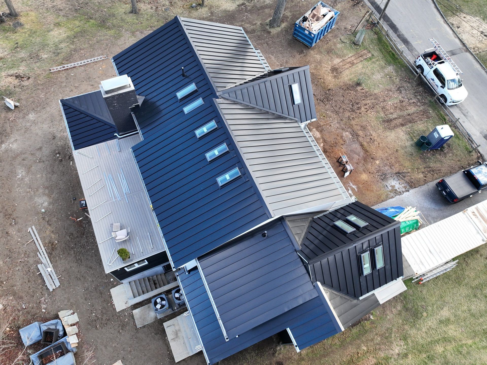An aerial view of a house under construction with a blue roof.